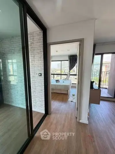 Modern apartment interior with spacious bedroom and large windows offering natural light.