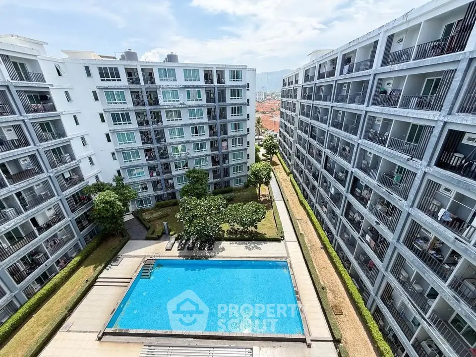 Modern apartment complex with central swimming pool and lush greenery, offering a vibrant community lifestyle.