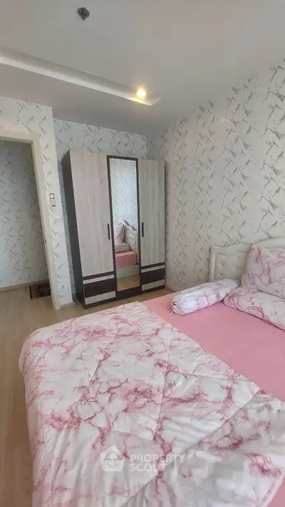Cozy bedroom with stylish wardrobe and elegant pink bedding in modern apartment.