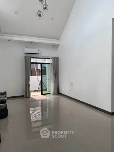 Spacious empty living room with high ceiling and modern lighting