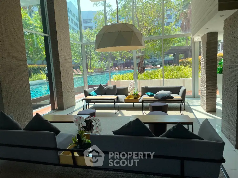 Luxurious lobby with modern seating and pool view, perfect for relaxation and social gatherings.