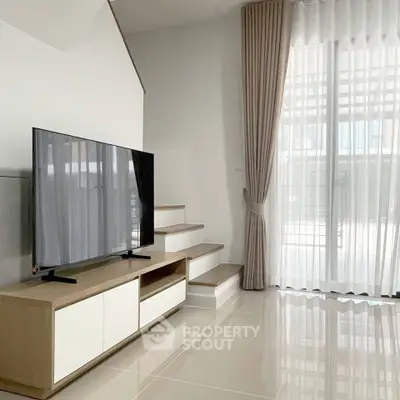 Modern living room with sleek TV stand and elegant curtains, featuring glossy tiled flooring.