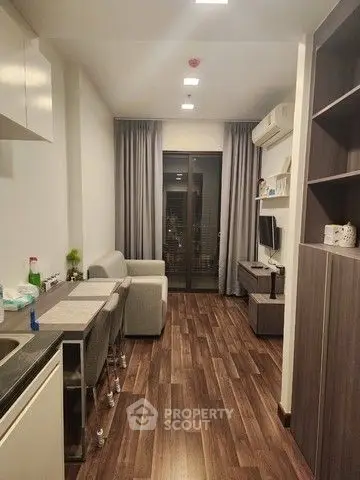 Modern living room with sleek furniture and wooden flooring, featuring a cozy ambiance and stylish decor.