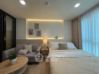 Modern bedroom with cozy decor and ambient lighting, featuring a comfortable bed and stylish sofa.