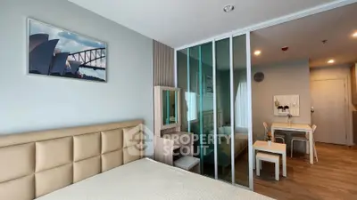 Modern bedroom with glass partition and cozy dining area in stylish apartment.