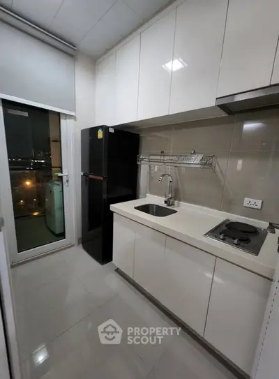 Modern kitchen with sleek cabinets and appliances, featuring a compact layout and city view.