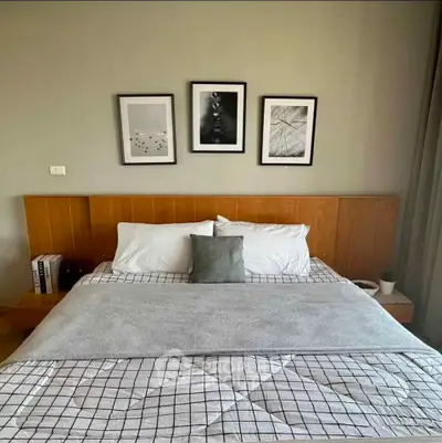 Cozy bedroom with stylish decor and modern artwork above the bed, perfect for relaxation.