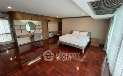 Spacious bedroom with elegant wooden flooring and modern furnishings