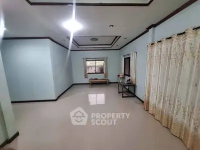Spacious living room with elegant ceiling design and large windows for natural light.