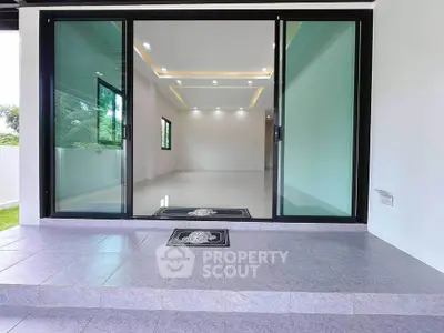 Modern empty living room with large glass doors and recessed lighting