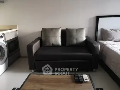 Modern studio apartment with cozy sofa and washing machine