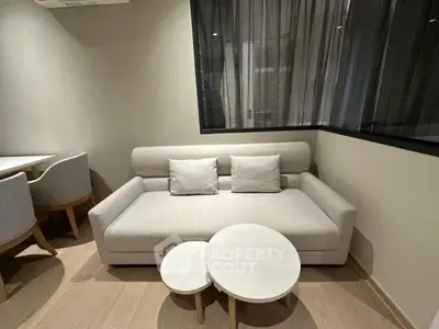 Modern living room with stylish sofa and nested coffee tables in a cozy apartment setting.