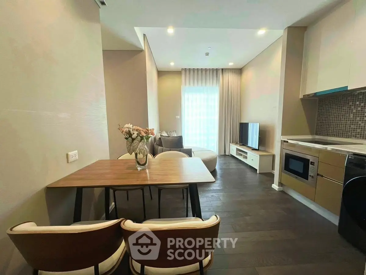 Modern living room with open kitchen, stylish decor, and natural light