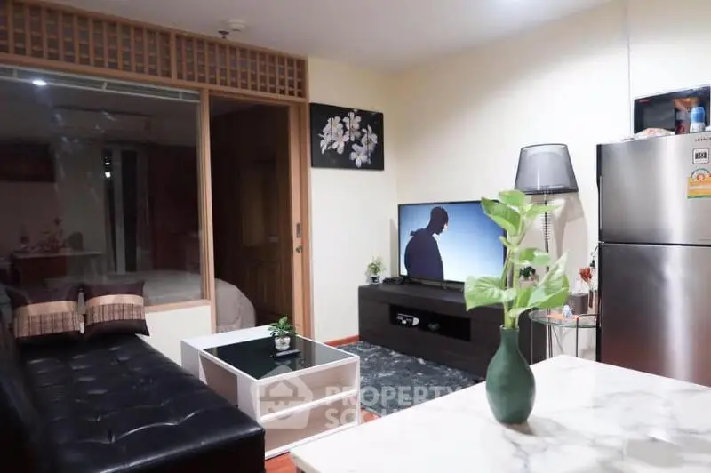 Modern living room with sleek furniture and open layout, featuring a stylish TV setup and elegant decor.