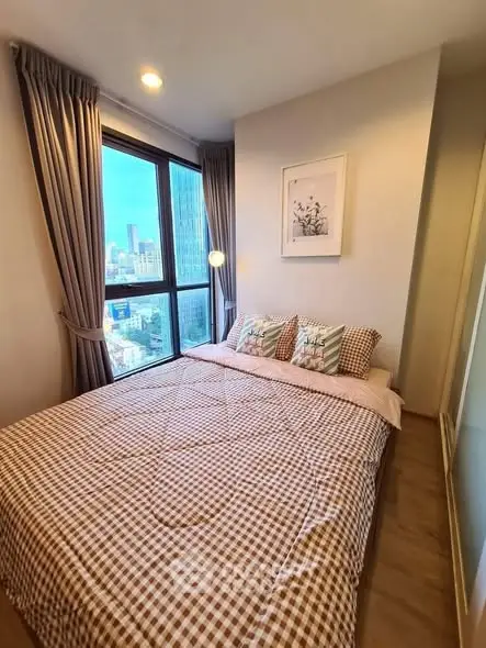 Cozy bedroom with city view, large window, and stylish decor in modern apartment.