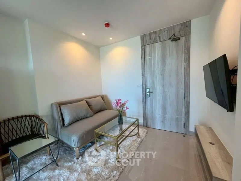 Modern living room with cozy sofa, stylish decor, and wall-mounted TV in a contemporary apartment.