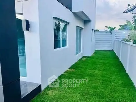 Modern exterior view of a sleek building with lush green lawn