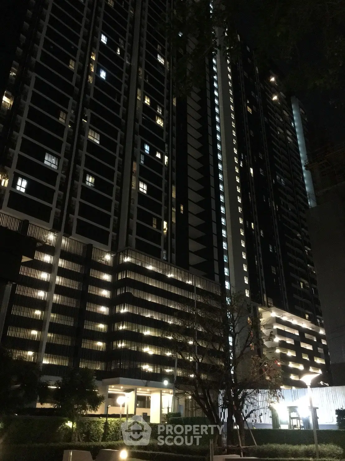 Stunning night view of a modern high-rise residential building with illuminated windows.