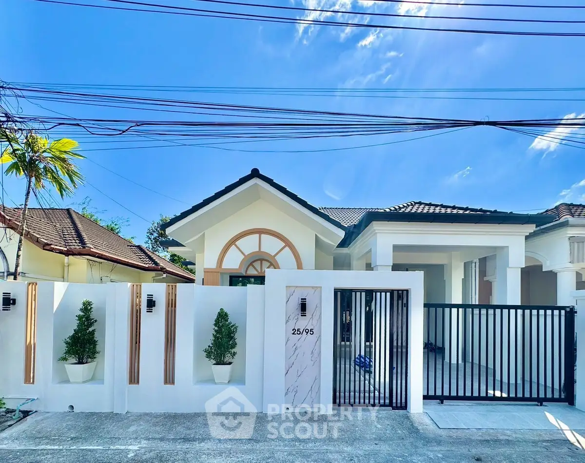 Charming single-story house with modern facade and gated entrance in a sunny neighborhood.