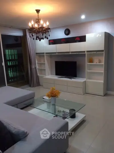 Modern living room with elegant chandelier and sleek entertainment center