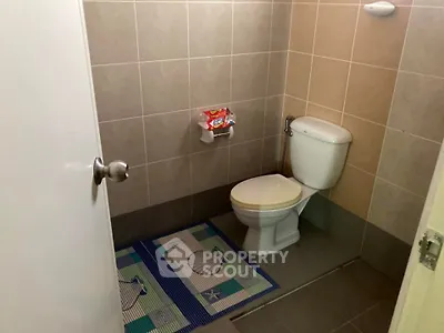 Cozy bathroom with tiled walls and modern fixtures, perfect for a compact space.