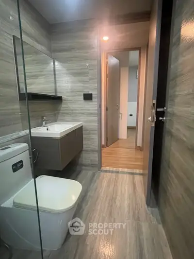 Modern bathroom with sleek design and wooden accents in a contemporary apartment.