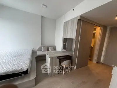 Modern bedroom with minimalist design featuring a bed, desk, and ample storage space.