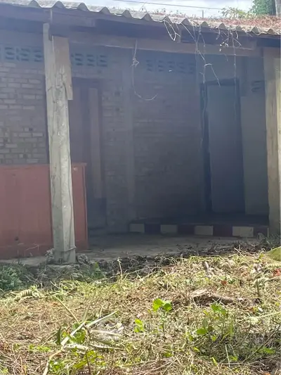Explore potential with this rustic property featuring brick exterior and overgrown garden, ideal for renovation.