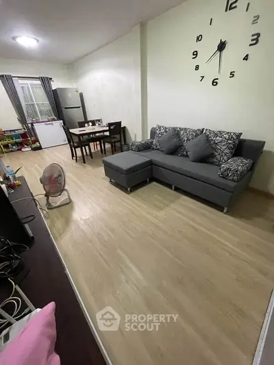 Spacious living room with modern sofa and dining area, perfect for family gatherings.