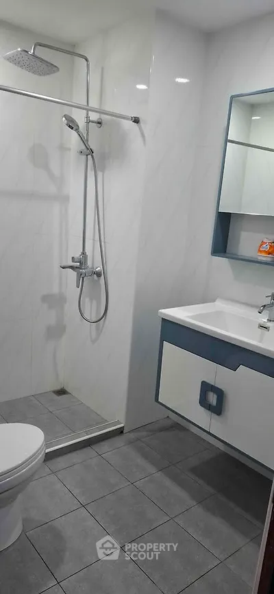 Modern bathroom with sleek shower and stylish vanity in contemporary apartment.