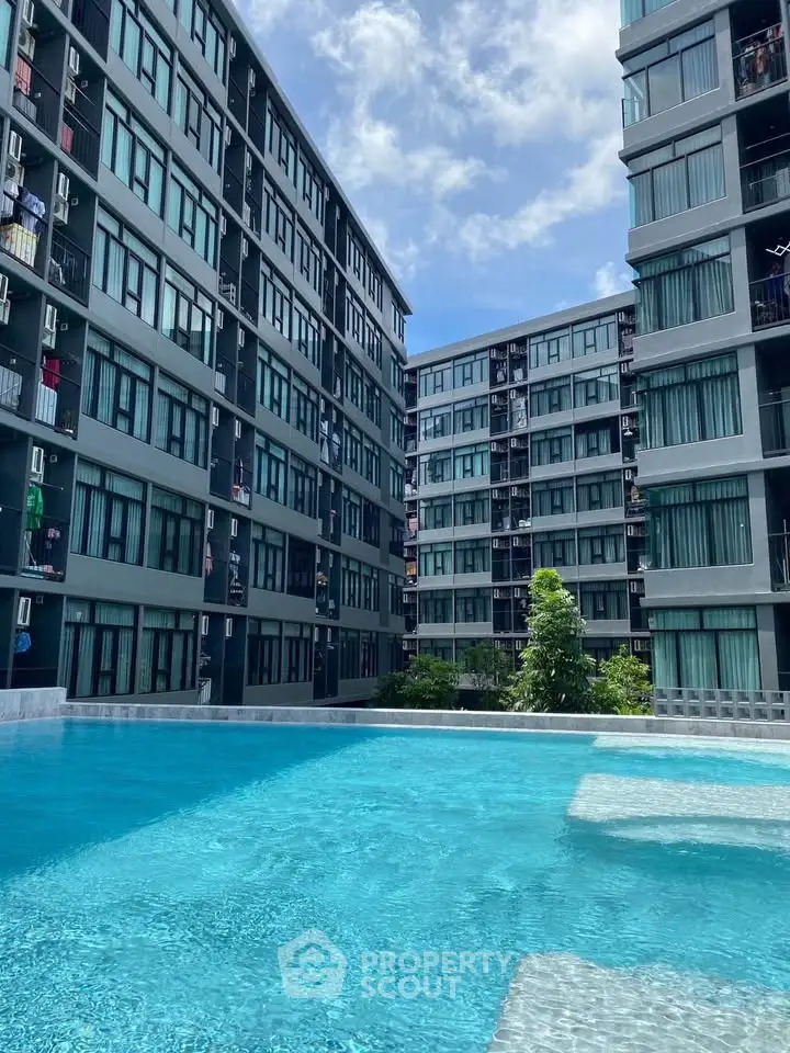 Modern apartment complex with a stunning outdoor pool and lush greenery, perfect for urban living.