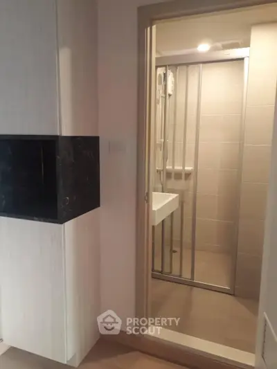 Modern compact bathroom with glass shower enclosure and sleek design