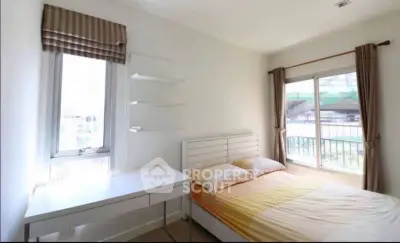 Bright bedroom with large windows and modern furnishings in a cozy apartment.