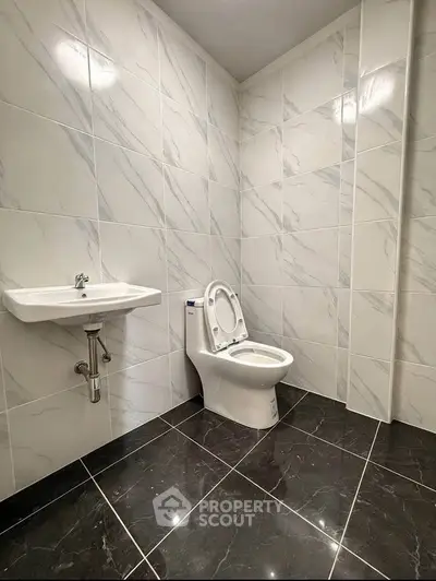 Modern bathroom with sleek marble tiles and contemporary fixtures.