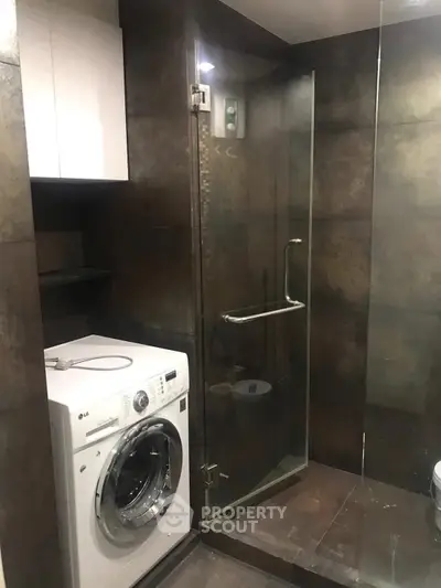 Modern bathroom with glass shower and washing machine