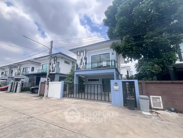 Modern two-story house with a sleek design and spacious driveway in a suburban neighborhood.