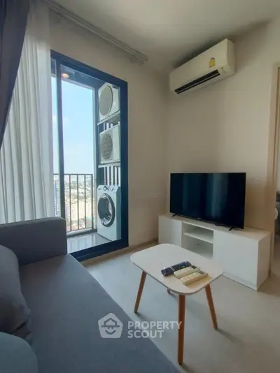 Modern living room with balcony view, featuring air conditioning and stylish furniture.
