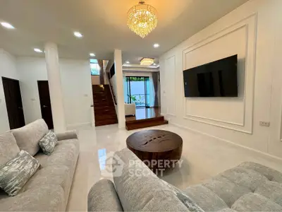 Luxurious living room with elegant chandelier and modern decor in a spacious open layout.