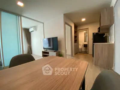 Modern open-plan living room with kitchen and dining area, featuring sleek furniture and contemporary design.