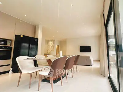 Spacious modern dining area with elegant chairs and large windows in a luxurious home.
