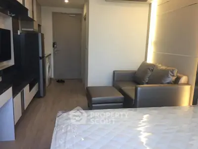 Modern studio apartment with sleek furniture and in-unit washing machine.