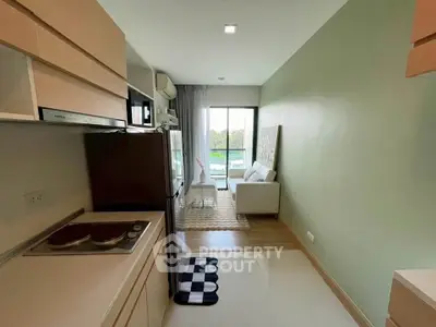 Modern open-layout kitchen and living room with natural light and balcony view.