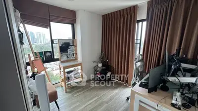 Modern study room with city view, featuring stylish desk and floor-to-ceiling windows.
