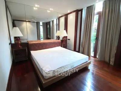 Luxurious bedroom with elegant wooden flooring and large windows for natural light.