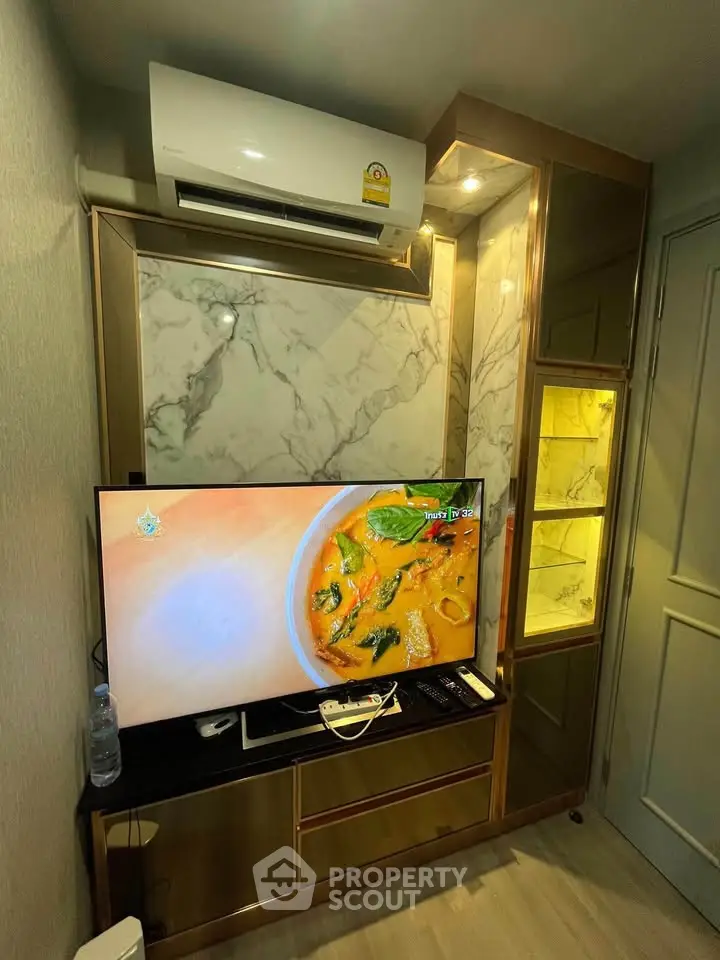 Modern living room with air conditioning and TV, featuring elegant marble accents and stylish cabinetry.
