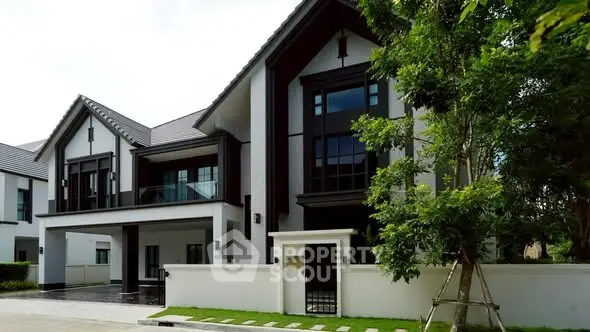 Luxurious modern house exterior with lush greenery and elegant architectural design.