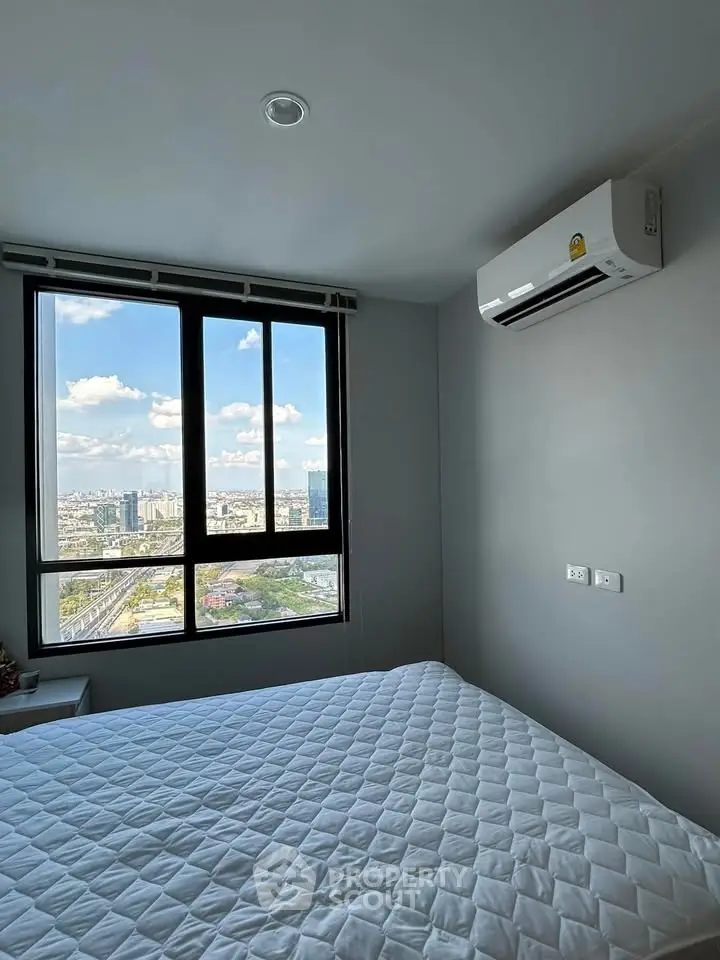 Modern bedroom with city view and air conditioning in high-rise apartment