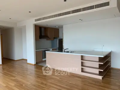 Spacious modern kitchen with open layout and wooden flooring in a stylish apartment.