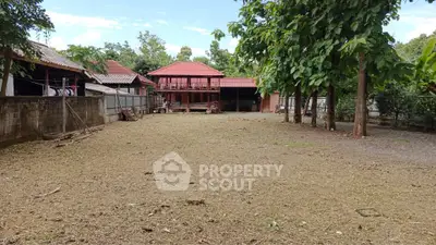 Spacious residential property with traditional architecture and large open yard, perfect for development.