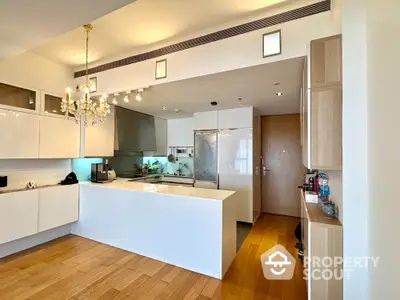 Modern kitchen with sleek white cabinets and elegant chandelier lighting